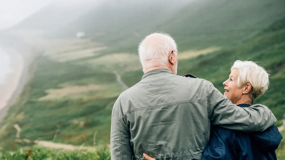 Happy senior couple enjoying a breathtaking view on vacation